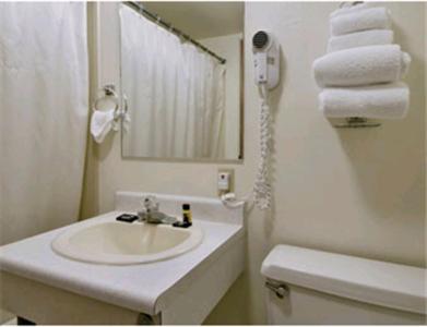 a bathroom with a sink and a toilet and towels at Travelers Inn in Longview