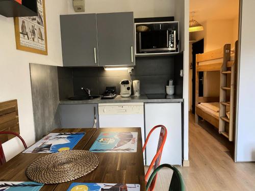 une petite cuisine avec une table en bois et une salle à manger dans l'établissement Résidence Doris - maeva Home - Studio 4 Personnes - Confort MAE-3919, à Arâches-la-Frasse