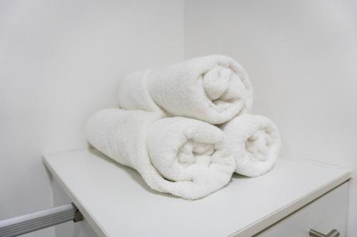 a pile of towels sitting on a white shelf at Puerto Santa Ana Luxury Suites Guayaquil in Guayaquil