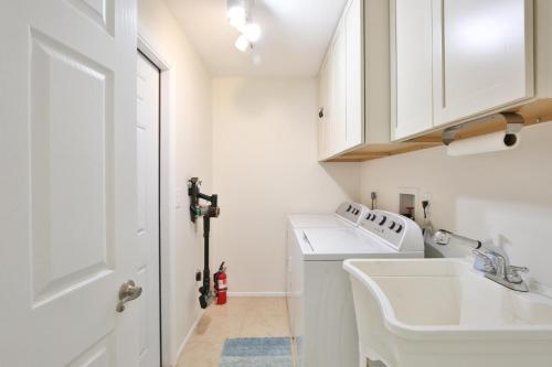 a white kitchen with a sink and a washing machine at Florida Vibes in Bradenton
