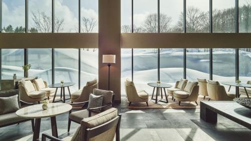 a lobby with chairs and tables and windows at ANA InterContinental Appi Kogen Resort by IHG in Hachimantai