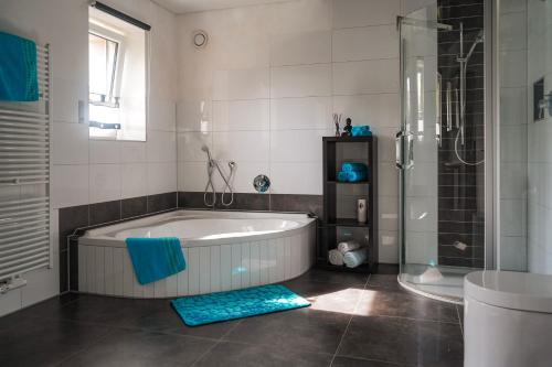 Un baño grande con bañera y ducha. en Ferienwohnung Christel und Andreas, en Sulzfeld