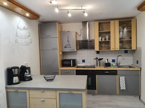 Una cocina con gabinetes de madera y encimera. en Ferienwohnung Christel und Andreas, en Sulzfeld