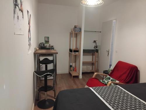 une chambre avec un lit, une table et une chaise dans l'établissement Le petit cocon, à Cerdon