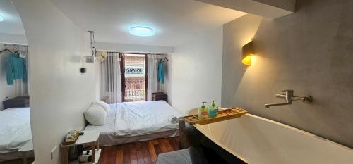 a bathroom with a tub and a bed in it at Bu House Hanoi Old Quarter in Hanoi