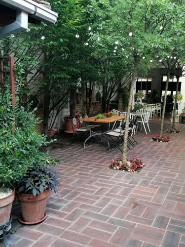 a patio with a table and chairs and trees at Apartments 135 in Vršac