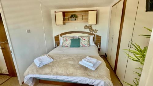 a bedroom with a bed with towels on it at Hoburne Devon Bay Holiday Home Fresh Bright Rental - Home from home in Torquay