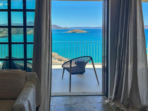 a room with a chair and a view of the ocean at Apartment Sunkiss in Almirida