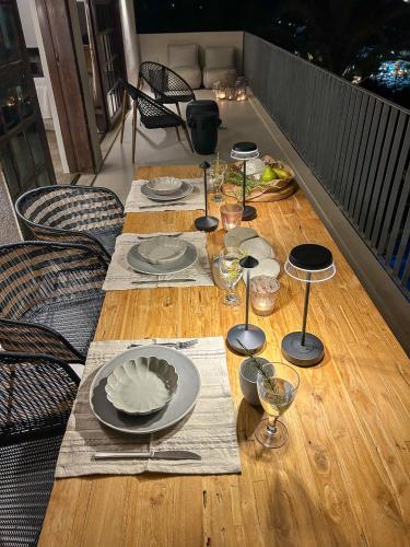 a wooden table with plates and wine glasses on it at Apartment Sunkiss in Almirida