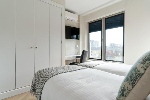 a bedroom with two beds and a window at Park Central Executive Apartments 102 in The Hague