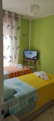 a room with two beds and a television in it at APPARTAMENTI RIMINI NEL CUORE in Rimini