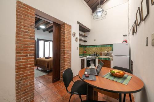 a kitchen with a table with a laptop on it at Apartamentos Antigua in Antigua Guatemala