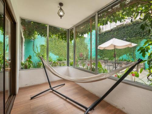 a hammock in a room with large windows at Apartamentos Antigua in Antigua Guatemala
