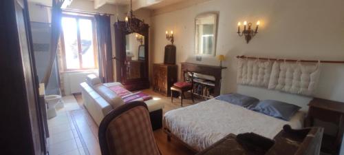 a bedroom with a bed and a couch and a chair at Le Moulin de Benechou in Olemps