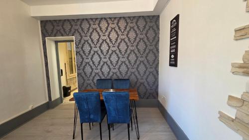 une salle à manger avec une table et des chaises bleues dans l'établissement Appartement 4 pers Vichy, à Vichy