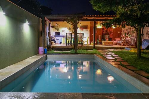 a swimming pool in a backyard at night at Comfort in the center of Piri - Casa Ipê Branco in Pirenópolis