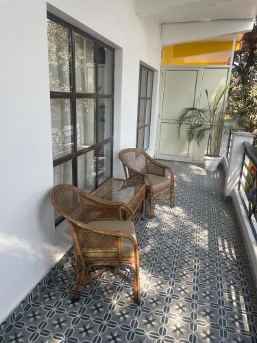 a patio with chairs and a table on a balcony at Silver Oaks Dalanwala by Jabula Getaways in Dehradun