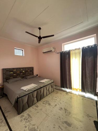 a bedroom with a large bed and a window at Silver Oaks Dalanwala by Jabula Getaways in Dehradun
