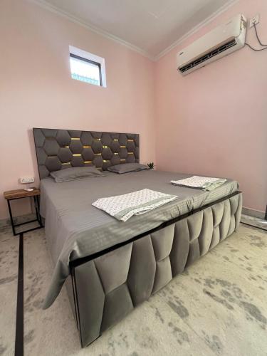 a bedroom with a large bed with a large headboard at Silver Oaks Dalanwala by Jabula Getaways in Dehradun
