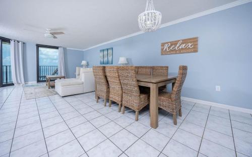 a dining room with a table and chairs and a couch at Phoenix IV 4053 condo in Orange Beach