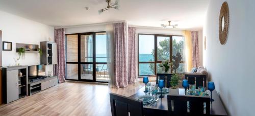 ヴァルナ・シティにあるCABA Apartmentのテーブルと大きな窓のあるリビングルーム