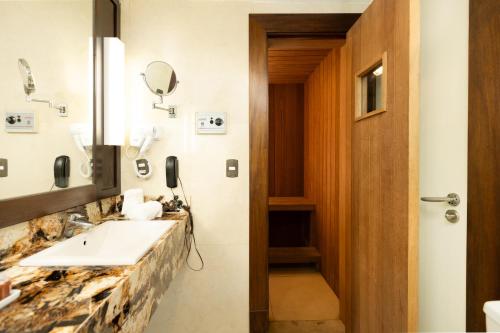 a bathroom with a sink and a mirror at Royal Atlântica Macaé Hotel in Macaé