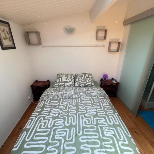 Cette chambre comprend un grand lit et 2 tables. dans l'établissement Duplex cosy Bordeaux centre, à Bordeaux