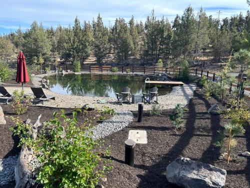 a garden with a pond and a table and chairs at Tumalo Ranch home in Tumalo