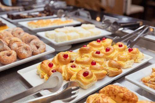 a buffet filled with different types of pastries and donuts at Royal Atlântica Macaé Hotel in Macaé