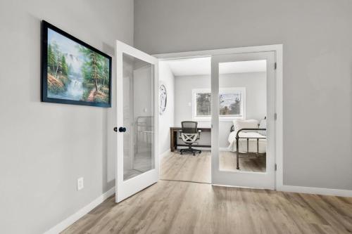 a white hallway with an open door and a bedroom at Tumalo Ranch home in Tumalo