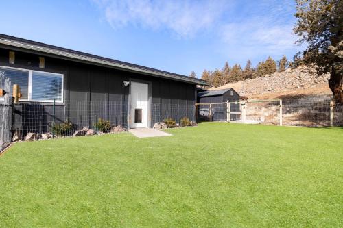a house with a grass yard next to a building at Tumalo Ranch home in Tumalo