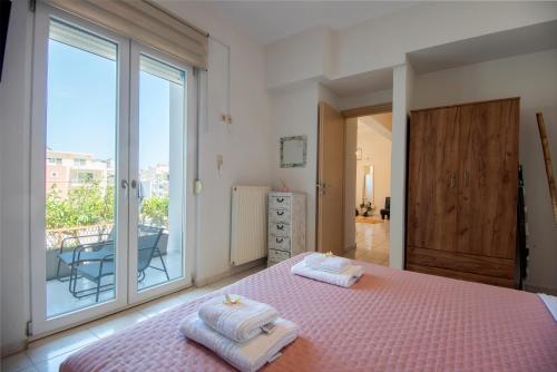 ein Schlafzimmer mit einem rosa Bett und einem Balkon in der Unterkunft 4Seasonsapts in Agios Nikolaos