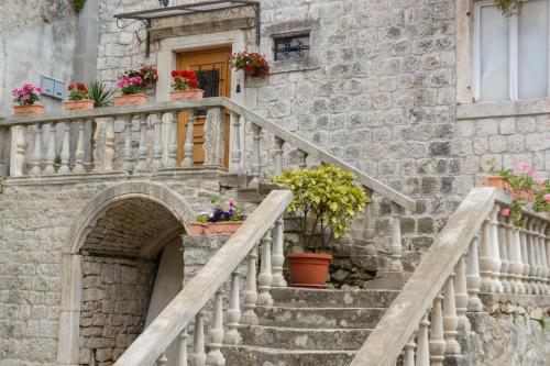 a stone building with stairs and potted plants at Guest House Exalto in Trogir