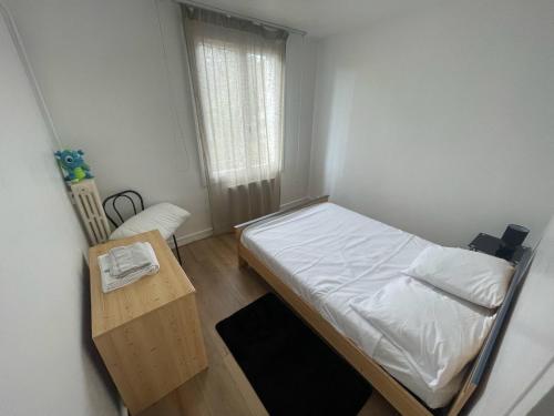 une petite chambre avec un lit et une table dans l'établissement Appartement 3 chambres, à Tours