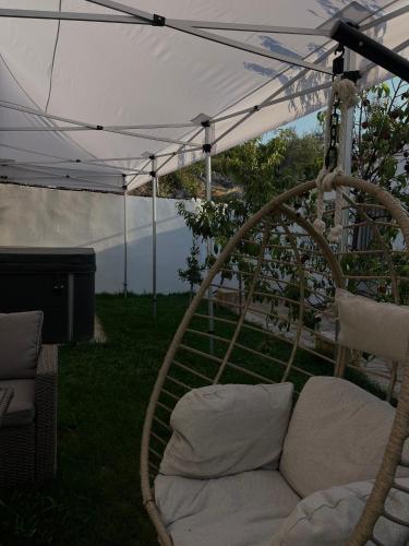 a couch sitting under an umbrella in a yard at Boho Escape - Jacuzzi & Sea View in Eretria
