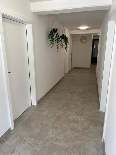 an empty hallway with white walls and tile floors at Odisej House Tolmin in Tolmin