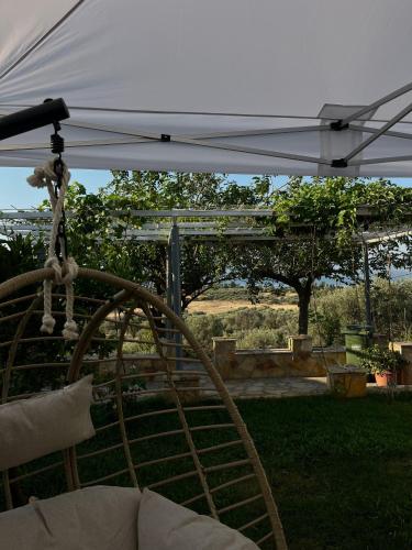 a swing under a white umbrella in a yard at Boho Escape - Jacuzzi & Sea View in Eretria