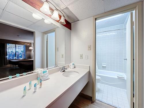 a bathroom with a sink and a toilet and a mirror at Stayable Jax West in Jacksonville
