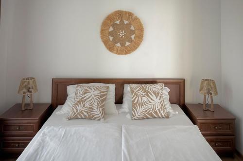 a bed with white sheets and pillows and two lamps at CABA Apartment in Varna City