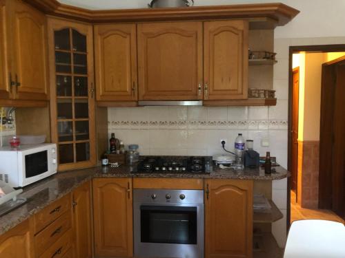 a kitchen with wooden cabinets and a stove top oven at Casa Flores in Amora