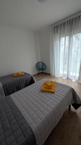a bedroom with two beds and a large window at Lake Garda Renovated Apartment in Torri del Benaco