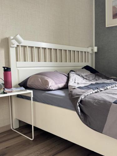 a bed with a white frame and a table at Chalet Boerennest bij strand en duinen - Midicamping Van der Burgh - Rockanje in Rockanje