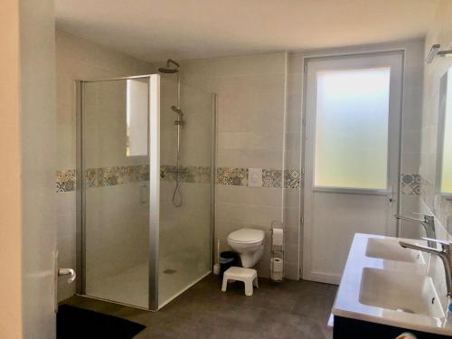 a bathroom with a shower and a toilet and a sink at Family home in Kerlouan