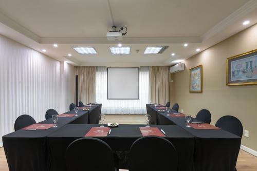 a conference room with a row of tables and chairs at Cala di Volpe Boutique Hotel in Montevideo