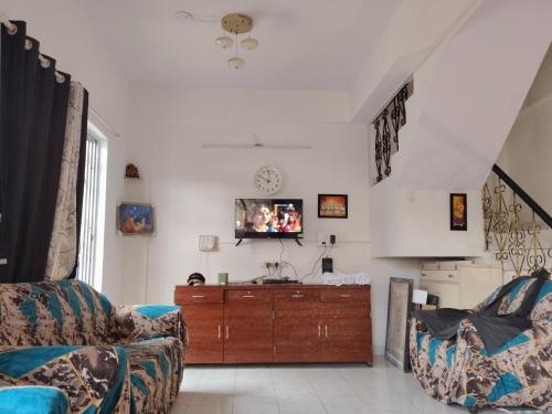 un soggiorno con un divano e una TV a parete di Capricorn villa a Lonavala
