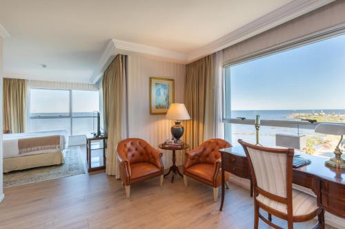 a hotel room with a desk and a bedroom with a view at Cala di Volpe Boutique Hotel in Montevideo