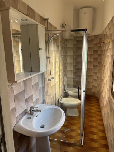Un baño con lavabo, inodoro y ducha. en Seahouse, en Caulonia Marina