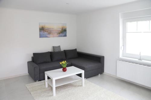 a living room with a black couch and a table at Feriendomizil "Putbus"WE16 in Putbus