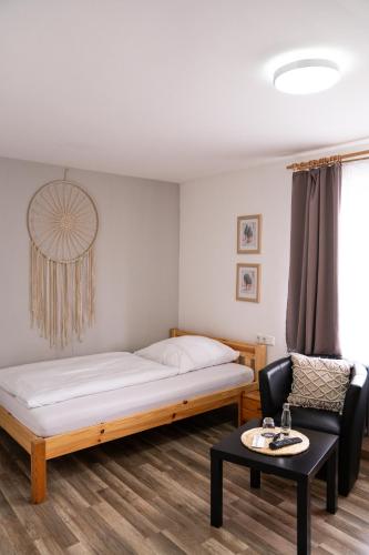 a bedroom with a bed and a chair and a table at Gasthof Wolfs Stuben in Reichenbach an der Fils