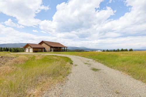 a dirt road leading to a house in a field at Mountain and Lake View Rexford Estate on 28 Acres! in Rexford